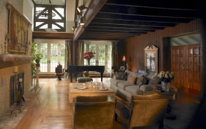 Furness Barn renovated living room view of wood paneling, floors, and ceiling beams, fireplace, and balcony in Haverford, PA