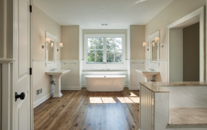 Red Fox Lane house bathroom with double vanity, bathtub, and wall paneling in Wayne, PA
