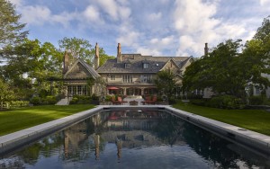 Ardrossan Estate backyard with large swimming pool and view of french normandy styled architecture in Villanova, PA